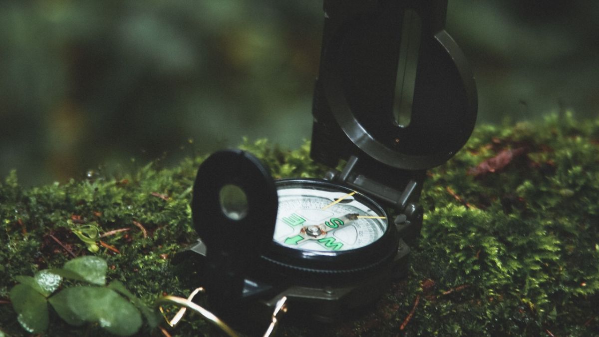 Kompass und Spielzeuge auf einem Blatt Papier mit Geocaching Anweisungen